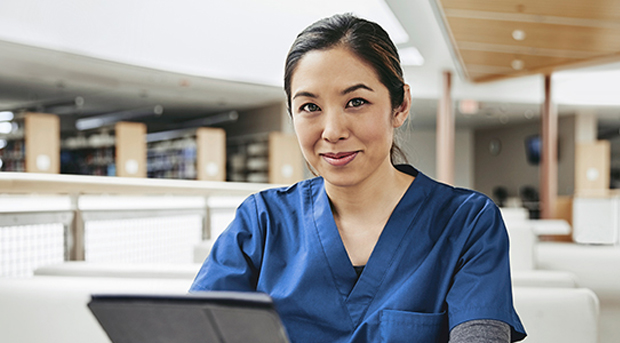 A nurse checks on her savings on her tablet computer.