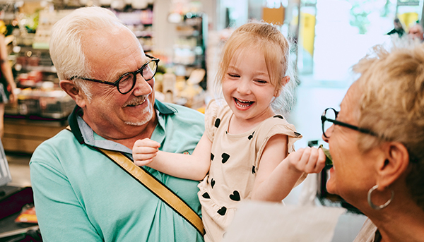 An older couple plays with their granddaughter.